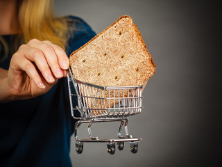 Woman hand holding shopping cart with bread