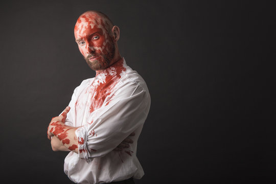 white bold bearded Caucasian male model guy man attractive wearing white shirt and black pants with red face paint makeup