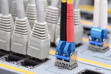 Optic fiber and network cables connected to switch in data center, internet network technology