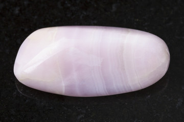 polished manganocalcite gemstone on dark