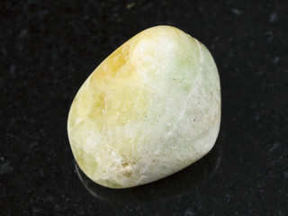 tumbled Datolite gemstone on dark background