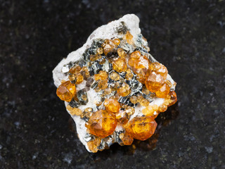 crystals of spessartine gemstone on dark