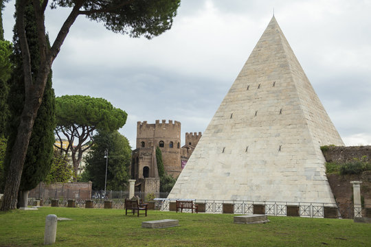 Vista della piramide di Caio Cestio a Roma, costituita da lastre in marmo lunense. In fondo le mura aureliane che hanno preservato la piramide nei secoli.