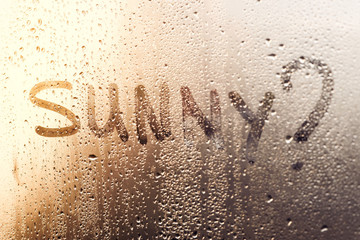 Rainy weather, the inscription on the sweaty glass - Sunny?
