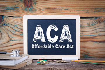 aca, affordable care act. Chalkboard on a wooden background.