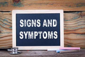 signs and symptoms. Chalkboard on a wooden background.