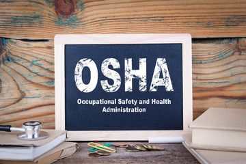 osha, Occupational Safety and Health Administration. Chalkboard on a wooden background.
