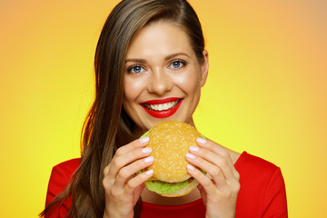 Smiling woman holding big burger.