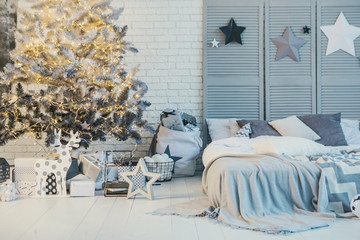 Winter holidays decorated bedroom interior. Christmas and New Year mood stars end tree