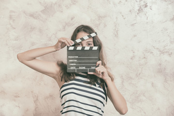 Fototapeta premium Woman with movie clapper board over face audition concept