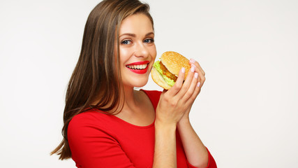 Smiling woman wearing red dress holding big burger.