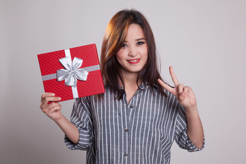 Asian woman show victory sign with a gift box.