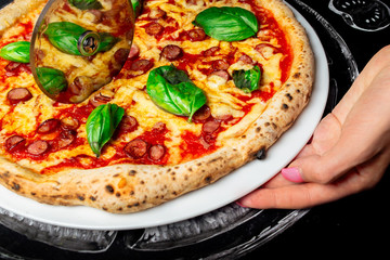 hand with pizza cutter