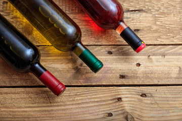 Wine bottles on wooden background, top view, copy space