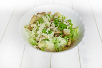 Mixed salad with green apple and walnuts on the table