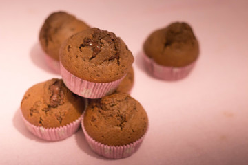 Chocolate muffins still life composition on pink background.