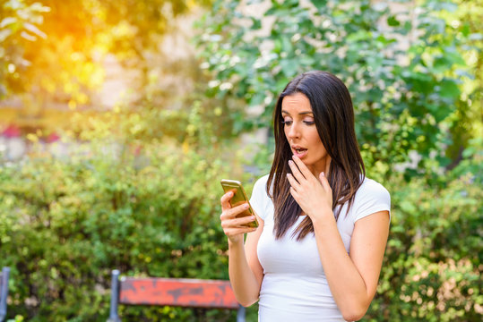 A young woman being upset while using her smartphone	