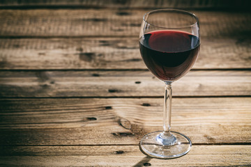 Red wine glass on wooden background