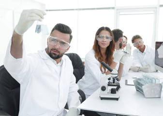Fototapeta premium biochemist with flask Petri sitting at a Desk
