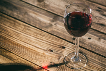Red wine glass on wooden background