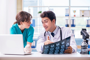 Two doctors discussing x-ray MRI image in hospital