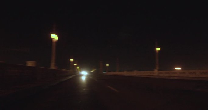 Slow motion, motorcycle pops wheelie on bridge