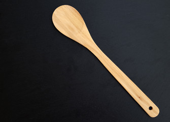 Wooden spoon over textured dark background