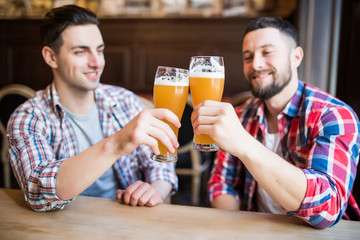 Cheers, my friend. Two handsome men is celebrating meeting and smiling.