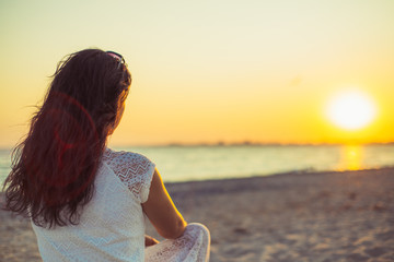 Brunette girl on the background of the sea sunset