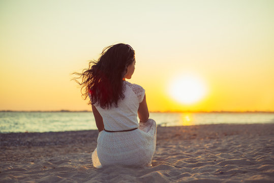 Brunette girl on the background of the sea sunset