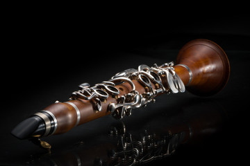 A light brown G-Clarinet lying on a reflective surface