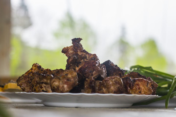 Ready to shish kebab on a snow-white plate Side view on a table with white wooden boards