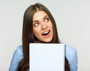 Surprising woman holding exercise book behind face.