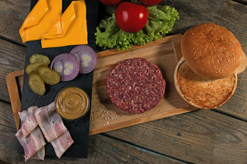 homemade cheeseburger fresh ingredients cheese, bun, salted cucumber, beef patties,bacon