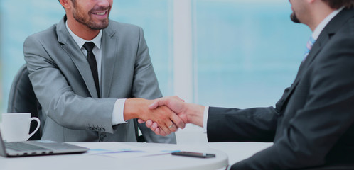 Two business people shaking hands with each other in the office