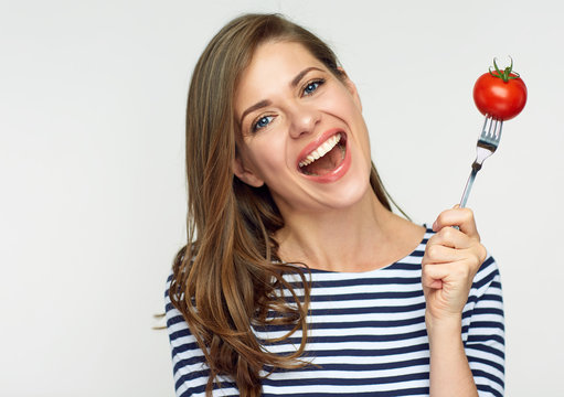 Happy woman holding fork with tomato.