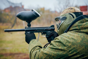 Man with gun playing at paintball. Outdoors