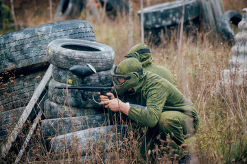 Man with gun playing at paintball. Outdoors
