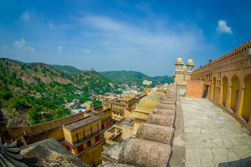 Fototapeta na wymiar Beautiful view of Amber Fort landscape and some rooftops of the buildings, near Jaipur in Rajasthan, India. Amber Fort is the main tourist attraction in the Jaipur area, fish eye effect