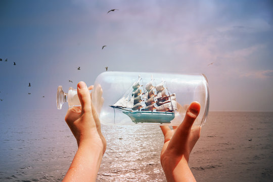 Textured image of a child holding a ship in a bottle at the ocean