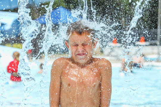 Boy at waterpark being hit with icy cold water
