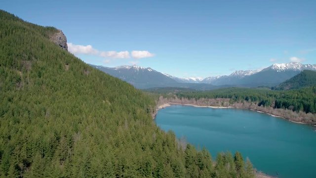 Cascade Mountain Range Dusted with Snow in Aerial Flying Over Turquoise Lake