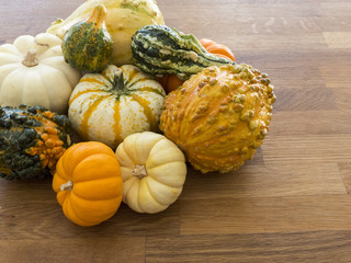 Overhead view of multi-colored gourds on a wood background 1