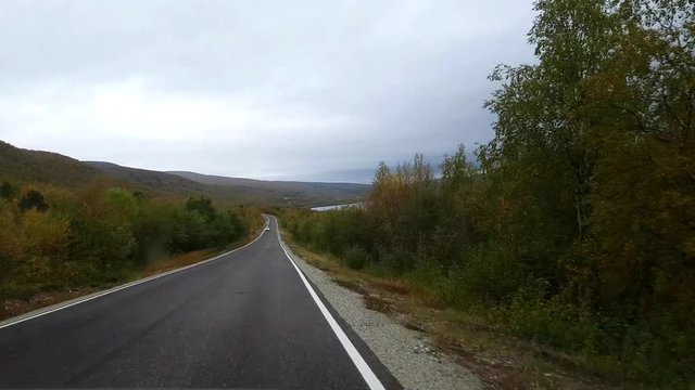 Autumn color road, Driving view on road 970 the tenontie, near tenojoki river, at the border of norway and utsjoki, on a sunny evening dawn, in Lapland, Finland