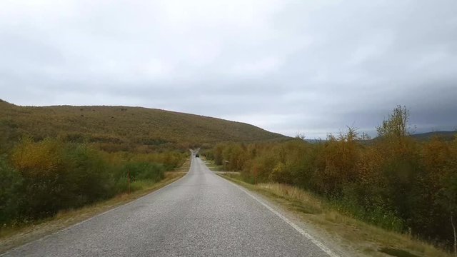 Autumn color road, Driving view of road 970 the tenontie, near tenojoki river, at the border of norway and utsjoki, on a cloudy day, in Lapland, Finland