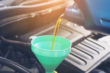 Pouring oil to car engine, selective focus
