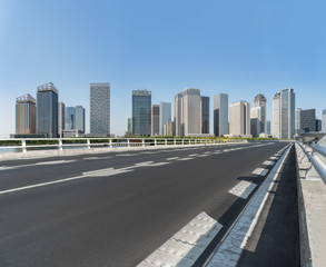 Fototapeta na wymiar road through the bridge with city skyline background