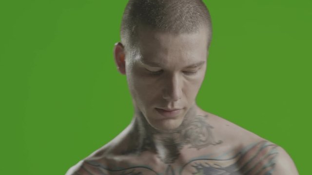 Handsome sexy young man stylish with tattoo on his neck, torso and hand - middle shot portrait studio - greenscreen Prores - cinematic lighting