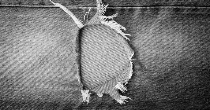 torn old black denim texture background