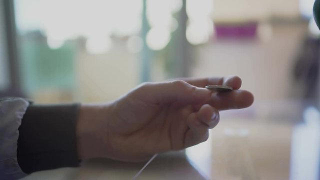 Man's hand nervously tossing euro coin in fingers trying to make right decision